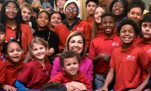 Governor Reynolds at the Student's First Bill signing, surrounded by children
