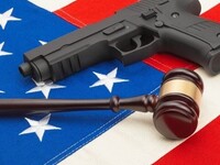 A gavel and firearm sitting on top of the American flag